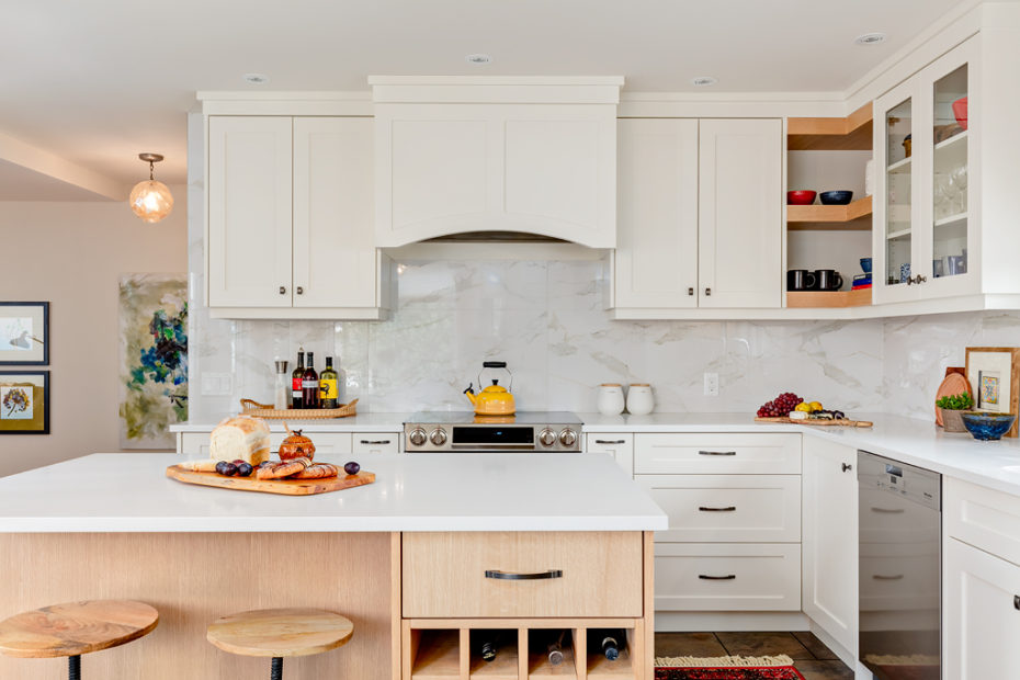 Bright white renovated kitchen with large scale tile backspace and quartz countertops.