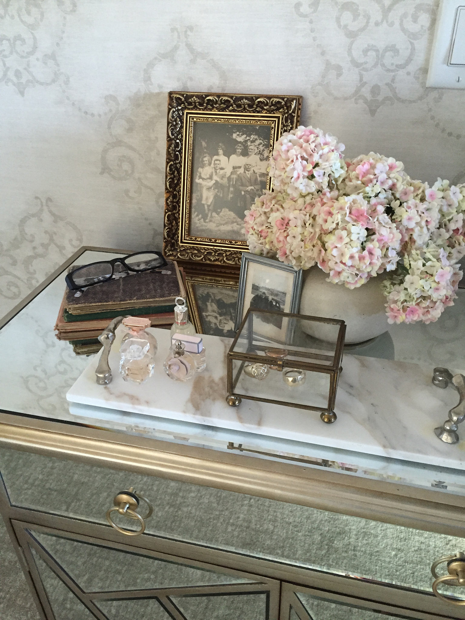 Table scape on mirrored chest features pretty flowers and a vintage family photo