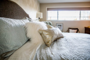 plain fabric of headboard offsets the textured bedding and sparkly cushion