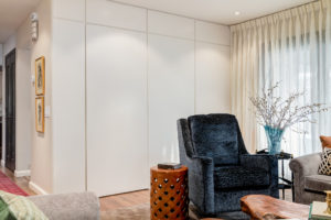 custom flat panelled wall makes an elegant backdrop to deep navy velvet chair