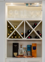 Detail of custom bar that sits behind a panelled wall.